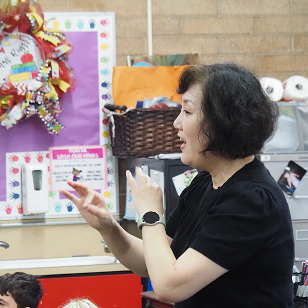 A music teacher guides students through a song