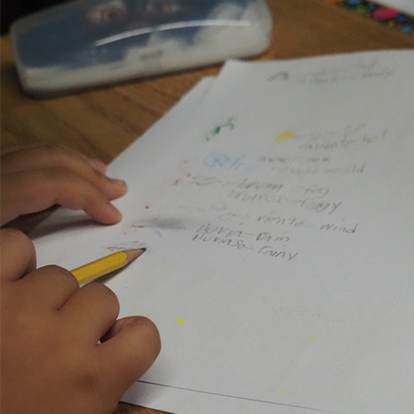 A close-up photo of a student's hands completing a Spanish lesson